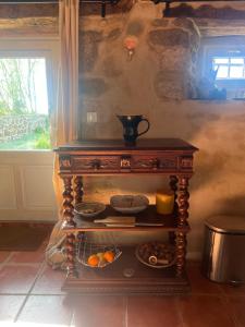 a wooden table with a shelf with food on it at La Maison du Tisserand maison entière à Bécherel in Bécherel