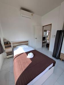 a bedroom with a bed with a hat on it at Lamae Beachfront Villa in Ban Laem No