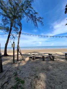 a picnic table and a tree on the beach at Lamae Beachfront Villa in Ban Laem No