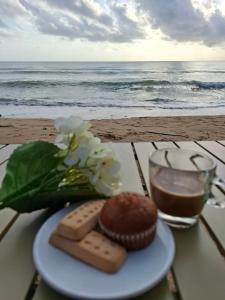 a plate with a chocolate cake and a glass of water at Lamae Beachfront Villa in Ban Laem No