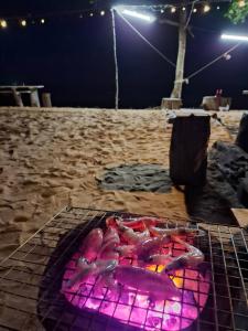 a grill with pink lights on a beach at night at Lamae Beachfront Villa in Ban Laem No