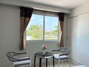 a dining room with a table and chairs and a window at DD Boutique Resort in Ban Wat Pa