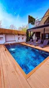 a swimming pool with chairs on a wooden deck at Shore of Sapanca Lake Çatı Villa Lakehouse in Kartepe