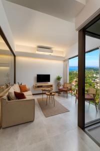 a living room with a couch and a tv at The Loft Mirissa in Mirissa