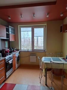 a kitchen with a table and chairs and a window at Prie Masčio ežero in Telšiai
