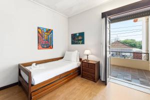 a bedroom with a bed and a large window at Casa da Betinha in Ílhavo