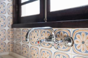 a bathroom sink with a faucet on a tiled wall at Casa da Betinha in Ílhavo +46 photos