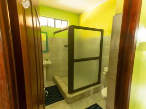 a bathroom with a shower and a toilet and a mirror at Merlin Guest House in Rodrigues Island
