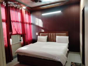 a bedroom with a large bed with red curtains at Hotel Diamond palace 45C in Chandīgarh