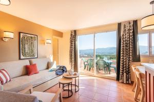 a living room with a couch and a table at Village Pierre & Vacances Pont Royal en Provence in Mallemort
