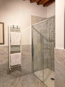 a shower with a glass door and towels at Guardastrada Country House in Monteroni dʼArbia +28 photos