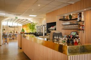 a bar in a restaurant with a counter at Hôtel Restaurant Atrachjata in Aléria