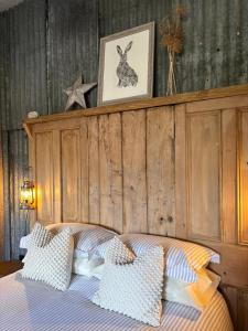 a bedroom with a bed with a wooden headboard at The Pig and Sty in Hereford