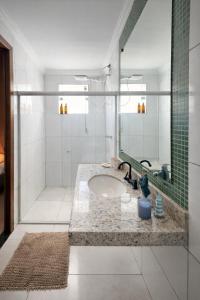 a bathroom with a sink and a large mirror at Apê 202 - Central, Garagem e Ar Cond - 2Q e 2B in Governador Valadares