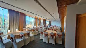 a conference room with tables and chairs and large windows at Rosetum Kasauli in Kasauli