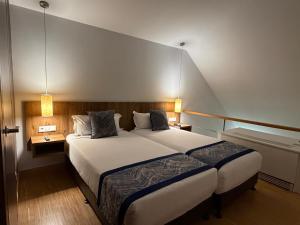 ein Schlafzimmer mit einem großen weißen Bett und zwei Lampen in der Unterkunft Hotel Villa Odon in Villaviciosa de Odón + 79 Fotos