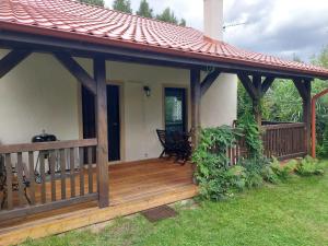 a large wooden deck with a house at Domek nad jeziorem, łódka, kajak in Zalewo