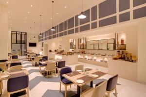 a restaurant with tables and chairs and a kitchen at Keys Prima by Lemon Tree Hotels, Whitefield, Bengaluru in Bangalore