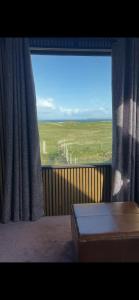 a room with a window with a view of a field at Seaside Suite Quilty in Quilty