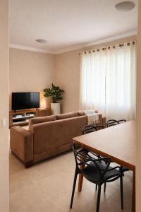 a living room with a couch and a table at Apê 202 - Central, Garagem e Ar Cond - 2Q e 2B in Governador Valadares