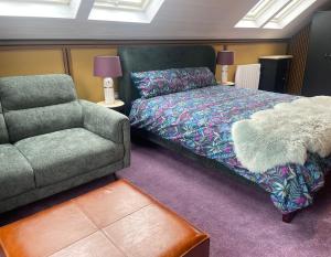 a bedroom with a bed and a couch and a chair at Seaside Suite Quilty in Quilty