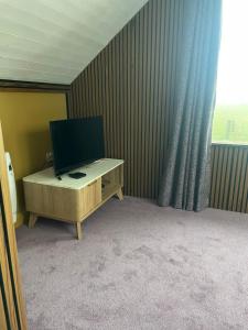a room with a television on a desk with a window at Seaside Suite Quilty in Quilty +10 photos