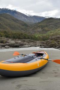 an orange kayak sitting on the sand on a beach at Wild Camping Vjosa in Përmet
