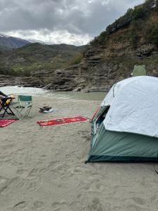 a tent on a sandy beach next to a river at Wild Camping Vjosa in Përmet
