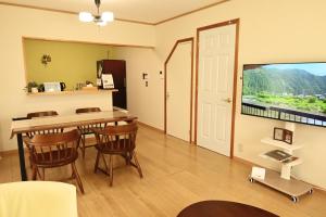 a dining room with a table and chairs and a window at ホリデーハウス慈野(ジノ) in Takayama