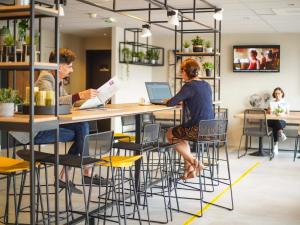 two people sitting at a bar with their laptops at Ibis Tours Centre Giraudeau in Tours