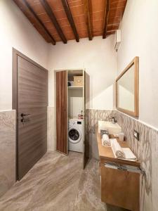 a bathroom with a sink and a washing machine at Guardastrada Country House in Monteroni dʼArbia