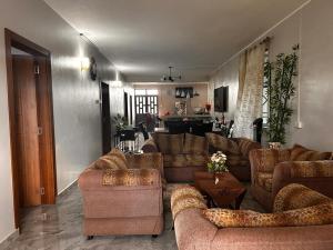 a living room with brown couches and a table and a kitchen at cozy home in Argy +1 photo