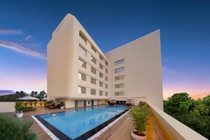 an exterior view of a hotel with a swimming pool at Keys Prima by Lemon Tree Hotels, Whitefield, Bengaluru in Bangalore