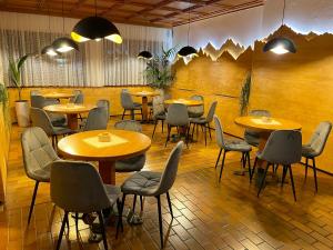 a restaurant with tables and chairs in a room at Hotel Waldheim in Sarnonico