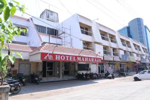 a hotel with a red sign in front of a building at Hotel Maharaja in Rewa