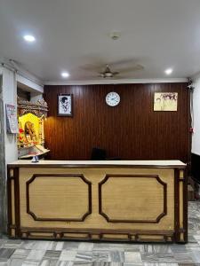 a counter in a room with a clock on the wall at Hotel Maharaja in Rewa
