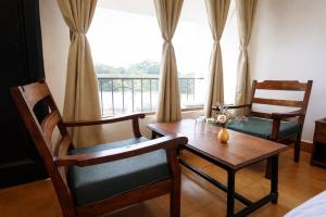 a dining room with a table and chairs and a window at Hotel Maharaja in Rewa