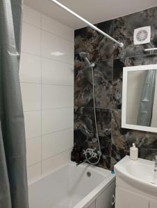 a bathroom with a white tub and a sink at Dolce Vita in Ternopil