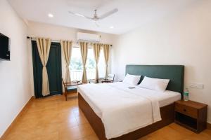 a bedroom with a large bed and a window at Hotel Maharaja in Rewa +3 photos