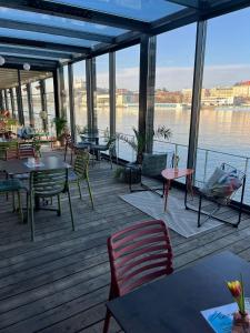 a restaurant with tables and chairs and a view of the water at Sundeck botel - party boat in Bratislava