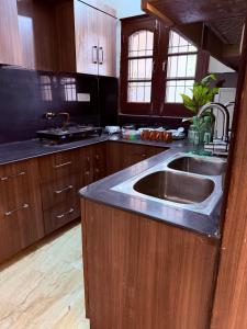 a kitchen with a large sink and wooden cabinets at Your Cozy Escape in Jammu