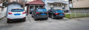 two cars are parked in front of a house at Apartman Lena lux in Vrnjačka Banja