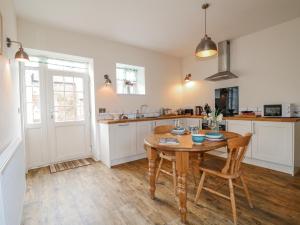 a kitchen with a wooden table and chairs in it at The Granary Barn at America Lodge in Oakham