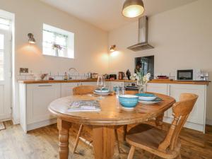 a kitchen with a wooden table and a table and chairs at The Granary Barn at America Lodge in Oakham +14 photos