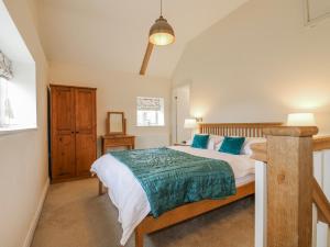 a bedroom with a large bed with blue pillows at The Granary Barn at America Lodge in Oakham