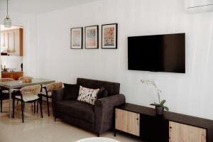 a living room with a couch and a tv on a wall at Toma Villa in Paralimni