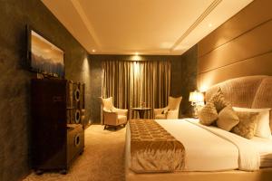 a hotel room with a bed and a table and chairs at Le Meridien, Surat in Surat