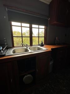 a kitchen with a sink and a window at Boskoors in Hammanskraal