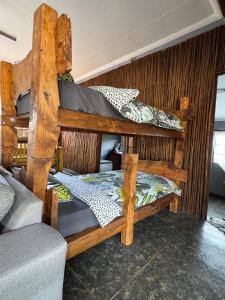 two bunk beds in a room with a couch at Boskoors in Hammanskraal