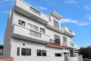 a white building with a qop sign on it at Hotel O Rest & Zone Hotel in Greater Noida